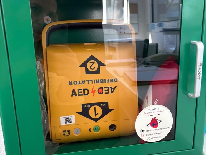 Desfibrilador AED en vitrina verde instalado en una zona de oficinas