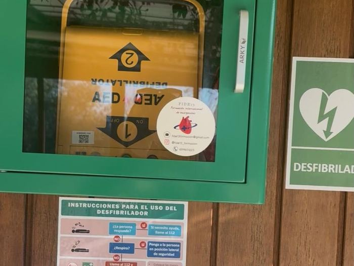 Vitrina de desfibrilador instalada en un porche, con las instrucciones a la vista