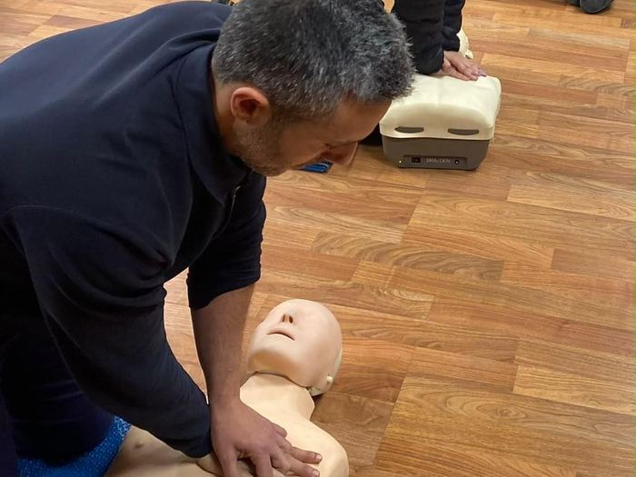 Alumnos practicando compresiones torácicas con maniquíes