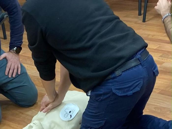 Alumno practicando compresiones con el desfibrilador de entrenamiento conectado