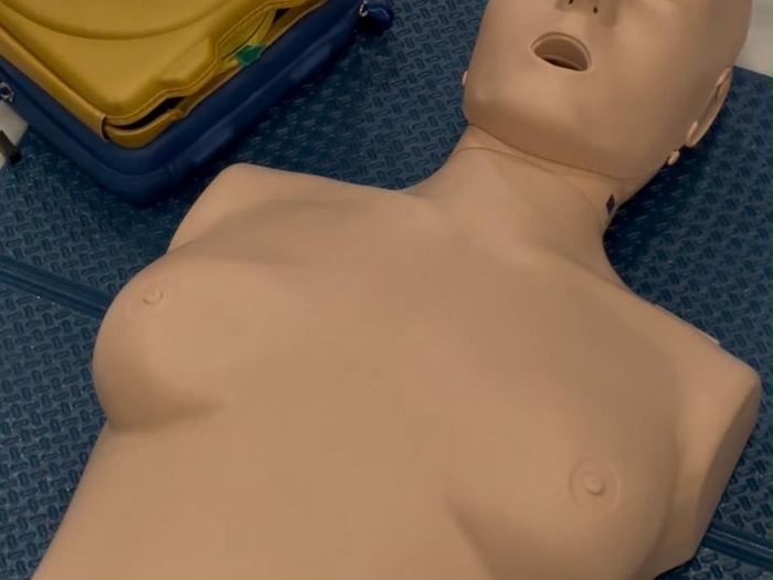 Maniquí de anatomía femenina y desfibrilador de entrenamiento listos para la práctica