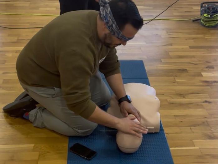 Alumno practicando la RCP con los ojos vendados durante un ejercicio del curso