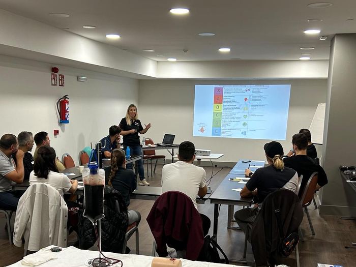 Sesión teórica del curso Stop The Bleed con la valoración XABCDE proyectada en el aula