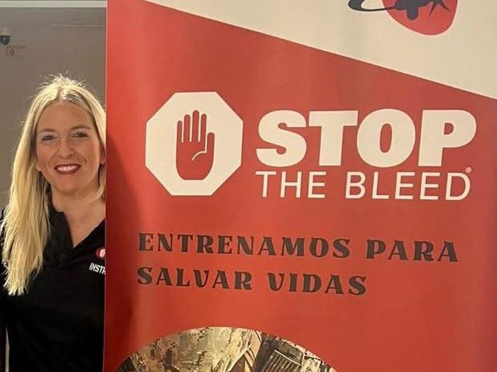 Beatriz García Ayllón, instructora de Stop The Bleed, junto al cartel del curso